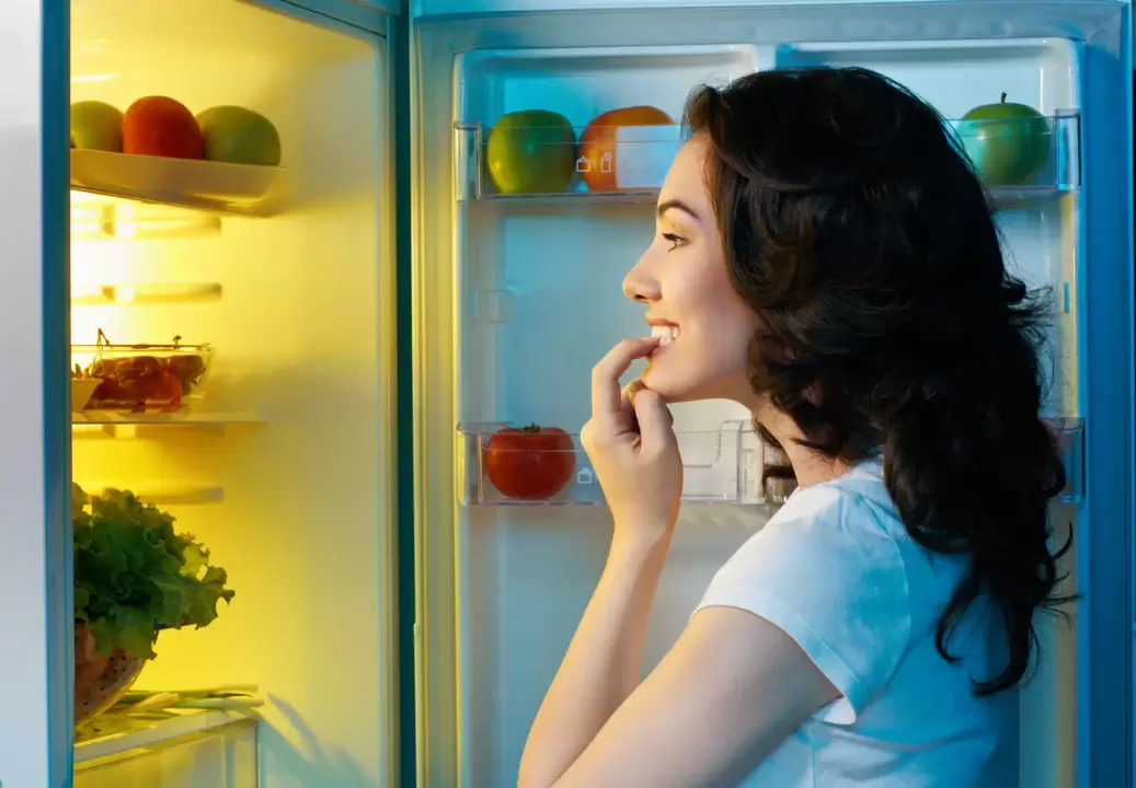 дівчина дивиться в холодильник під час швидкого схуднення